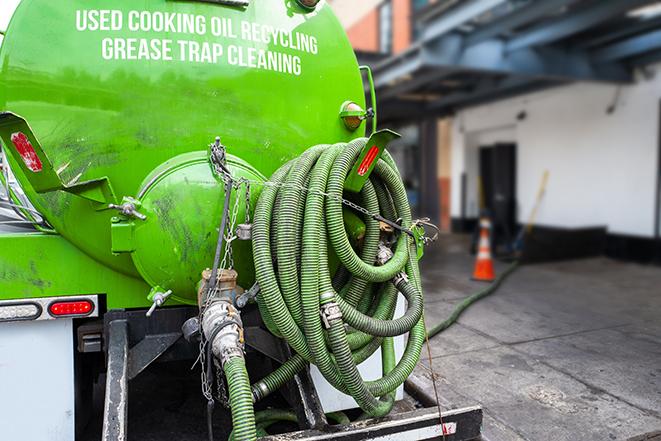 worker pumping grease trap at commercial kitchen in Davenport